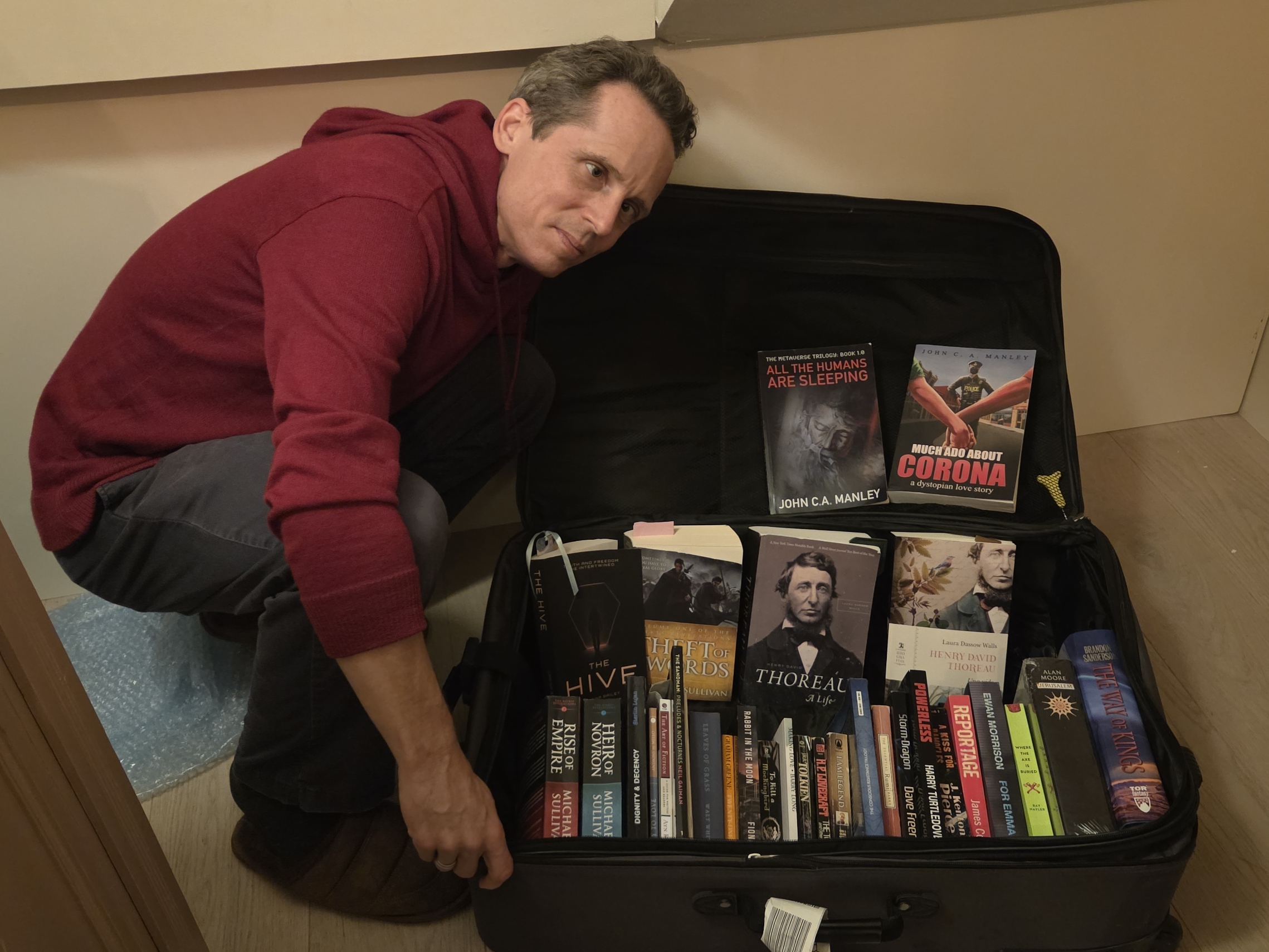 Books stacked beside four suitcases