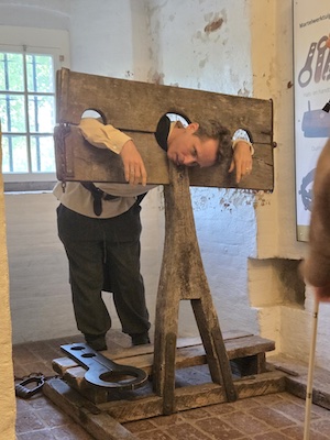 John depicted as a prisoner in a medieval cell